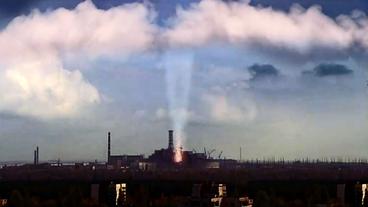 Das Atomkraftwerk Tschernobyl mit einer Staubsäule, die bis zu den Wolken reicht