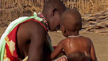 Afrikanische Mutter badet ihr Kind