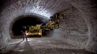 Bohrgerät und Arbeiter in Tunnel im Salzstock