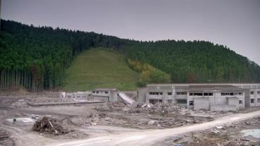 Zerstörtes Schulgelände mit Hügel hinterm Haus