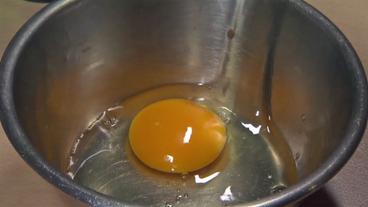 Ein aufgeschlagenes Ei in einer Schüssel