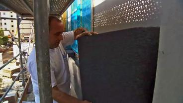Bild: NDR Ein Mann bringt eine Dämmplatte an einer Fassade an