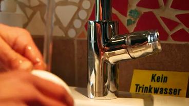 Bild: BR Wasserhahn, im Hintergrund eine Schild mit der Aufschrift "kein Trinkwasser"