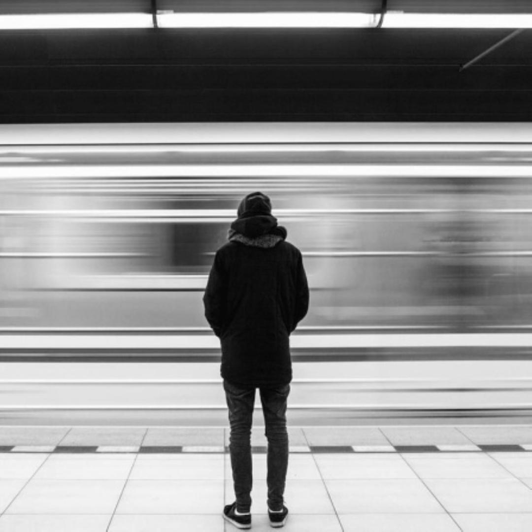 Mann steht an einer U-Bahn Haltestelle