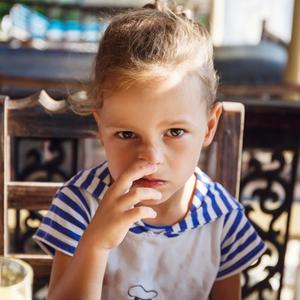 Mädchen mit Finger an der Nase