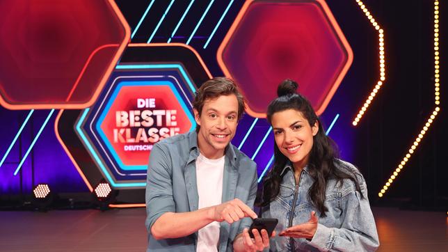 Bild: ARD/KiKA/Steffen Becker ARD/KIKA DIE BESTE KLASSE DEUTSCHLANDS - DAS SUPERFINALE, am Samstag (29.10.22) um 10:00 Uhr im ERSTEN. Das Moderations-Duo Clarissa Corrêa da Silva und Tobias Krell präsentiert Deutschlands cleverste Schulklassen und prominente Studiogäste.