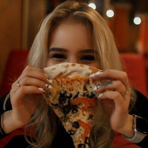 Eine Frau mit einem Stück Pizza