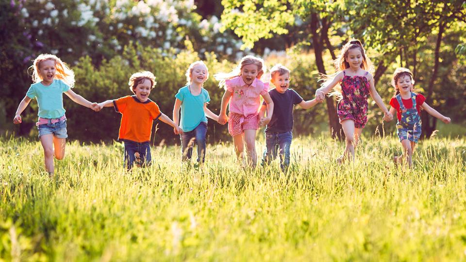 Kinder rennen auf einer Wiese