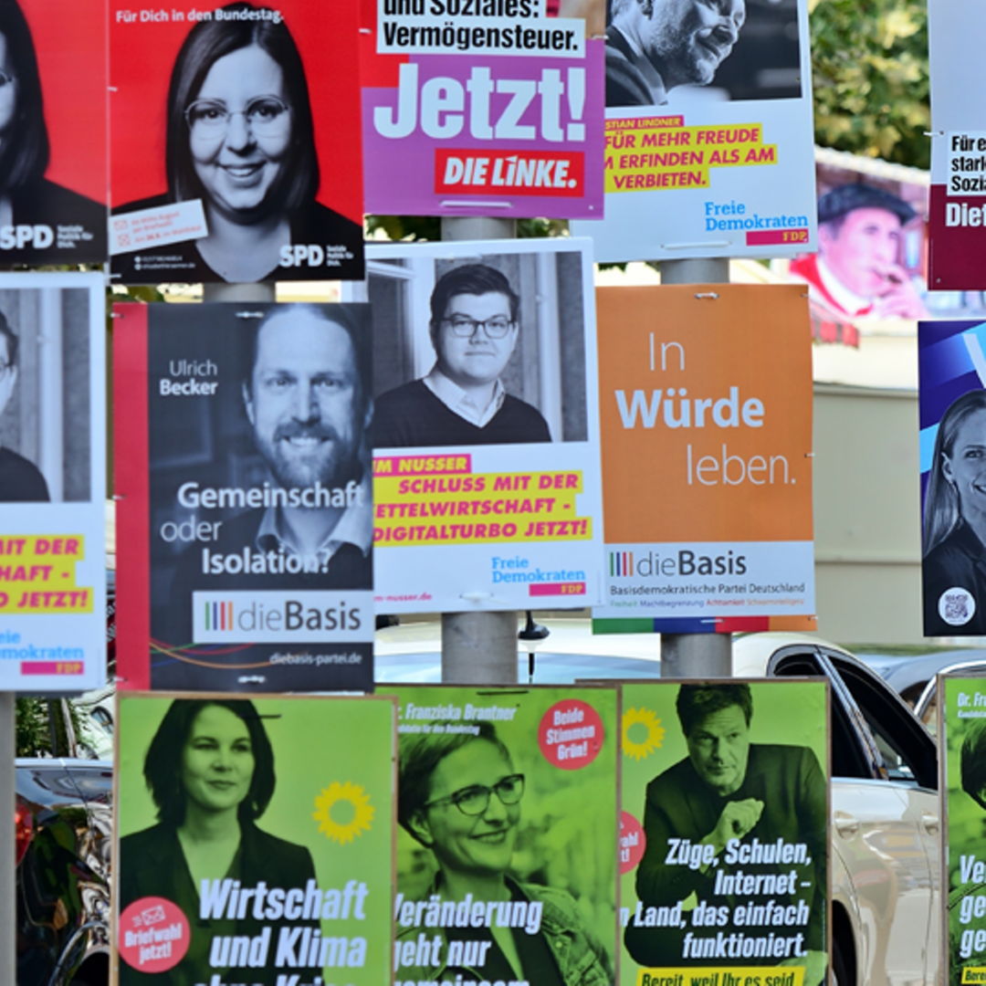 An Straßenlaternen hängen zahlreich Plakate von verschiedenen Parteien. An Straßenlaternen hängen zahlreich Plakate von verschiedenen Parteien.