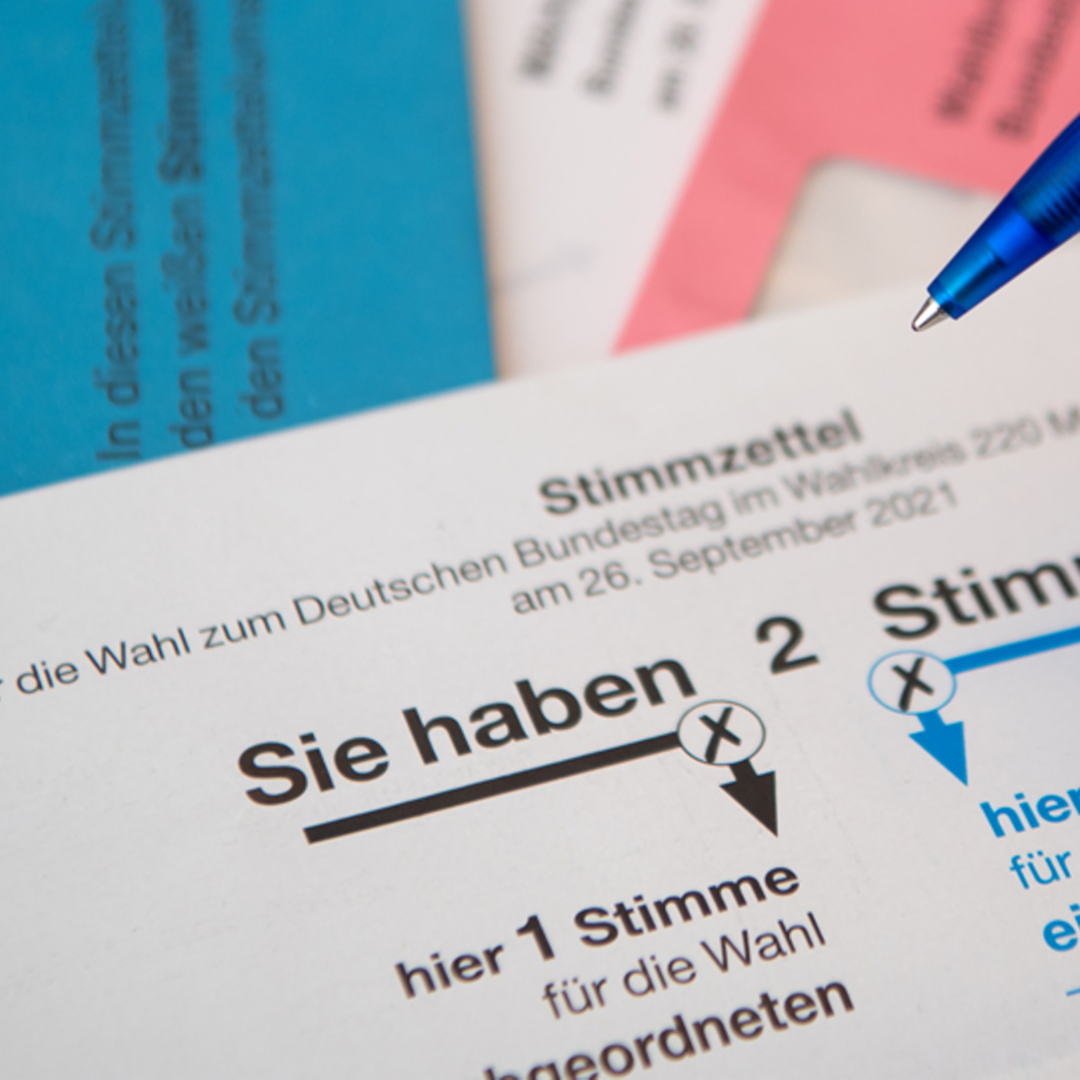 Briefwahlunterlagen für die Bundestagswahl 2021 mit Stimmzettel und Stimmzettelumschlag liegen auf einem Tisch. 