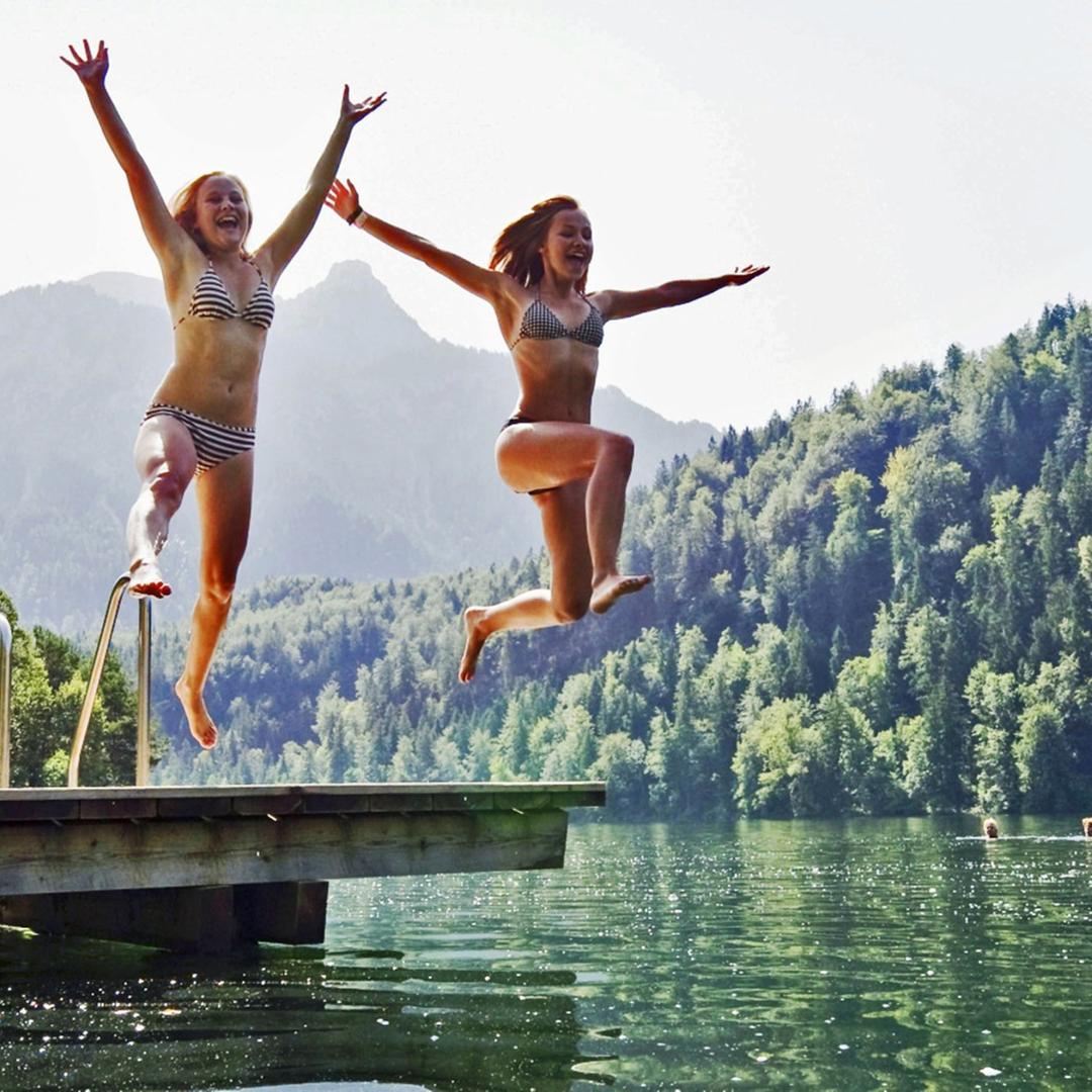 Zwei Frauen springen in einen See