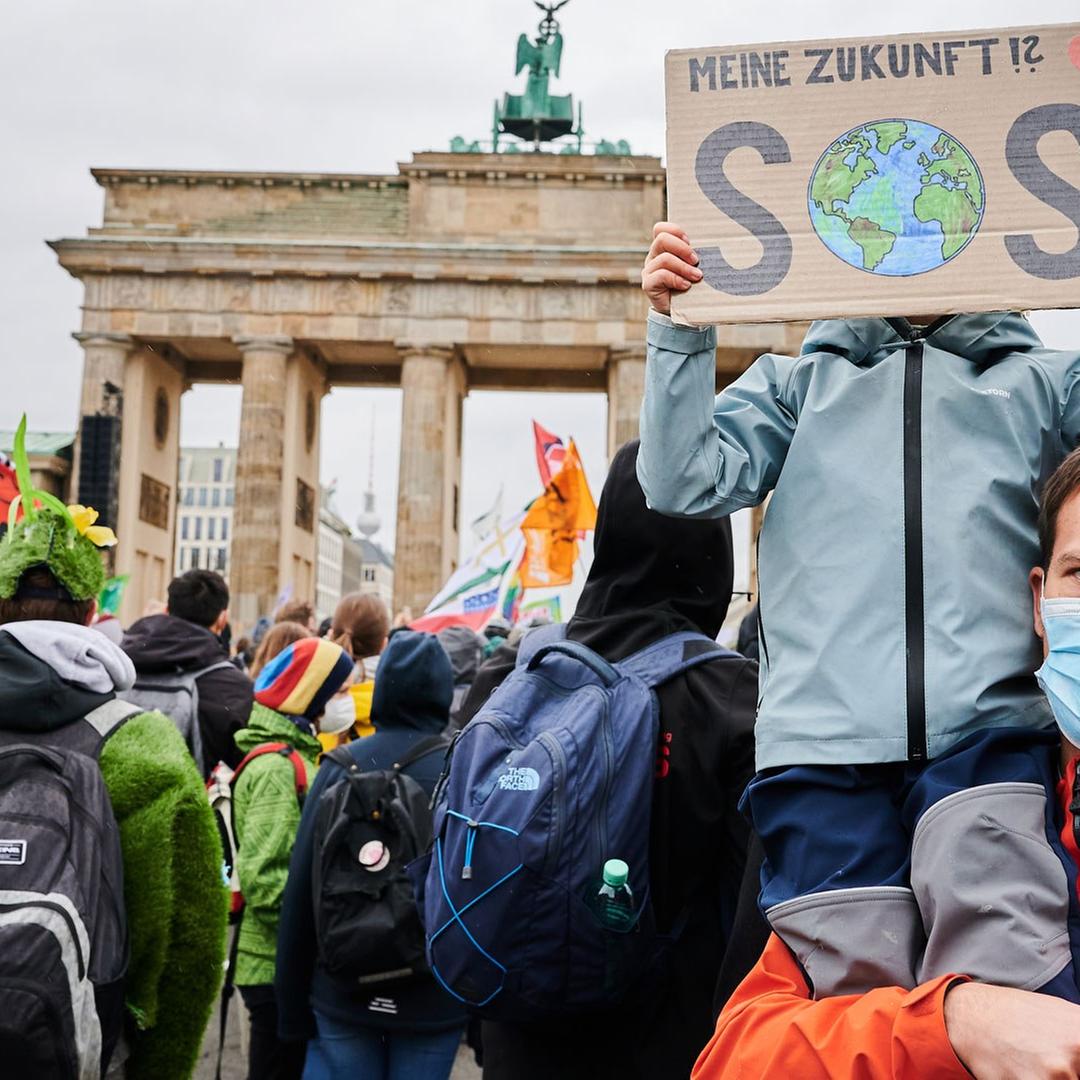 „Meine Zukunft SOS“ steht auf einem Transparent, das ein Kind vor sein Gesicht hält, während es bei seinem Vater vor dem Brandenburger Tor auf den Schultern sitzt. „Meine Zukunft SOS“ steht auf einem Transparent, das ein Kind vor sein Gesicht hält, während es bei seinem Vater vor dem Brandenburger Tor auf den Schultern sitzt.