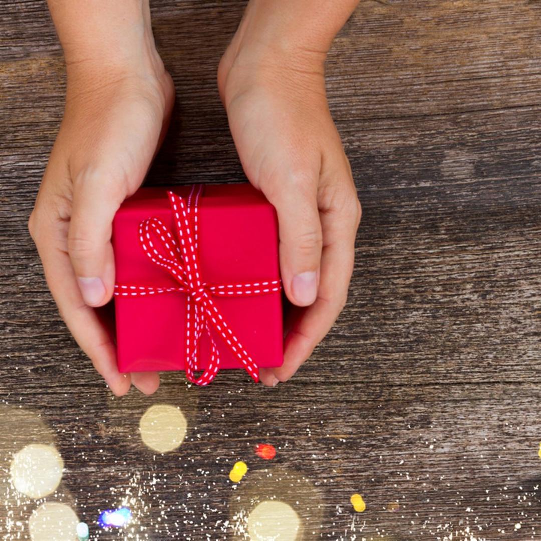 Hände mit einem Geschenk