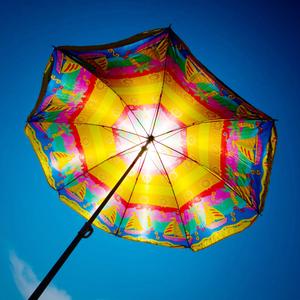 Ein bunter Sonnenschirm vor blauem Himmel