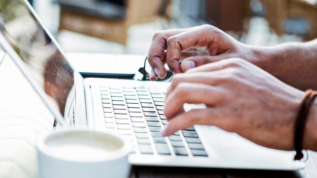 Bild: E+/Nastasic Person tippt auf Notebook-Tastatur
