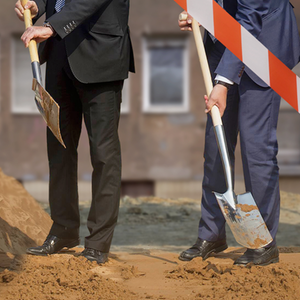 Cover "Teurer Wohnen": Anzugträger mit Schaufeln auf der städtischen Baustelle