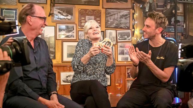 Bild: NDR/Morris Mac Matzen Gastgeberin Ina Müller begrüßt im "Schellfischposten" in dieser Sendung den Schauspieler Herbert Knaup und den Musiker Clueso, sowie die Sängerin Zaz mit ihrer Band. Foto: Herbert Knaup, Ina Müller und Clueso