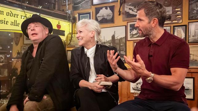 Bild: NDR/Morris Mac Matzen Gastgeberin Ina Müller begrüßt im "Schellfischposten" in dieser Sendung den Schauspieler Ben Becker und den Moderator und Autor Micky Beisenherz, sowie die Sängerin Griff und die Band Parcels. Foto: Ben Becker, Ina Müller und Micky Beisenherz