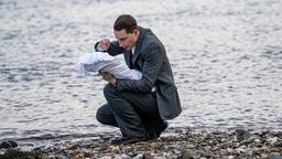 Emil (Jonathan Berlin) tauft sein Kind am Rhein.