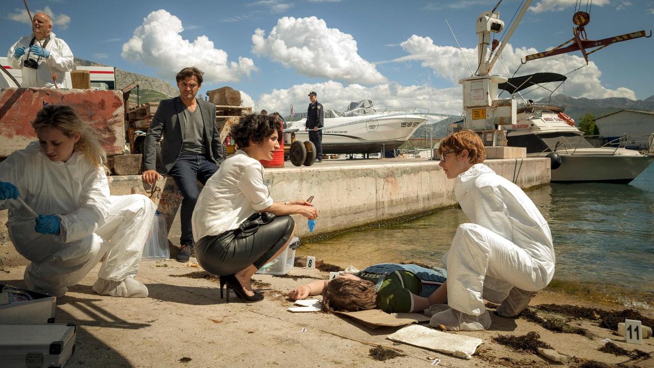 Kommissarin Branka Marić (Neda Rahmanian, Mitte), ihr Kollege Emil (Lenn Kudrjawizki, hinten) und Pathologin Brigitta Stevic (Sarah Bauerett, re.) finden eine Mädchenleiche im Industriehafen von Split.