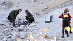 Rocco (Marco Giallini, li.) und sein Freund Fumagalli (Massimo Reale) beugen sich über die Leiche aus dem Fluß.