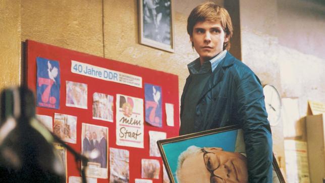 Alex Kerner (Daniel Brühl) muss der Geschichte Einhalt bieten: Seine alleinerziehende Mutter Christiane, verdiente Aktivistin der DDR, ist kurz vor dem Mauerfall ins Koma gefallen und erwacht erst acht Monate später. Jede Aufregung kann für sie lebensbedrohlich sein, also lässt Alex auf 79qm den real existierenden Sozialismus wieder auferstehen.