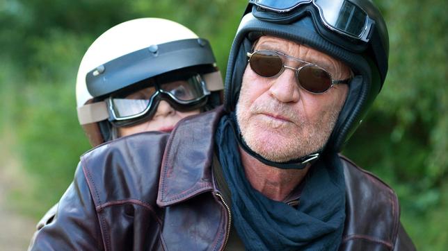Auf Harrys (Matthias Habich) Motorrad lässt Elly (Cornelia Froboess) sich in längst vergangene Zeiten entführen.