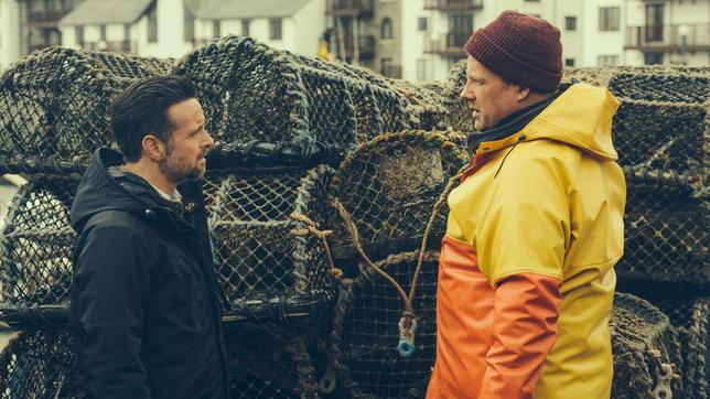 Bild: ARD Degeto Tom Mathias spricht am Hafen mit Mark Watkins.