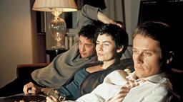 Karin, Frank und Robert sitzen nebeneinander auf dem Sofa und sehen fern. 