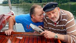 Klaus und Fred reparieren auf ihrem Segelboot ein Empfangsgerät.