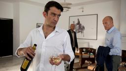 Sharif Nader mit einem Glas Wein, im Hintergrund Frank Henning. 