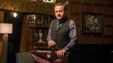 Bild: ARD Degeto/Hardy Brackmann Carlos (Samuel Finzi) ist der loyale Diener und engste Vertraute von Johann Friedrich von Allmen. Der ursprünglich aus Guatemala stammende Carlos ist auch ohne englische Herkunft der geborene Butler: Er bringt seinem Arbeitgeber, den er lediglich „Don John“ nennt, nicht nur das Frühstück ans Bett, sondern appelliert auch regelmäßig an dessen Vernunft.