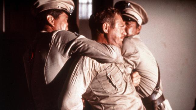 Der aufsässige Sträfling Henri Charrière alias Papillon (Steve McQueen) wird von Wärtern niedergerungen.