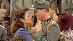 Der Frontsoldat Karlheinz Rombach (Timothy Peach)verabschiedet sich von seiner attraktiven Frau Eva (Christine Neubauer).