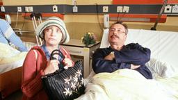 Erika Strunz (Katharina Thalbach) macht einen Krankenbesuch bei "ihrem" Mann Uwe Achimsen (Wolfgang Stumph).
