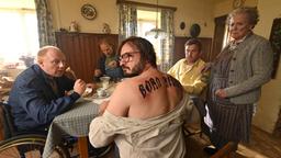 Flötziger (Daniel Christensen, Mitte) zeigt Rudi (Simon Schwarz, li.) der Eberhofer Vater (Eisi Gulp, 2. v. li.), dem Franz (Sebastian Bezzel) und der Oma (Enzi Fuchs) sein Tattoo.