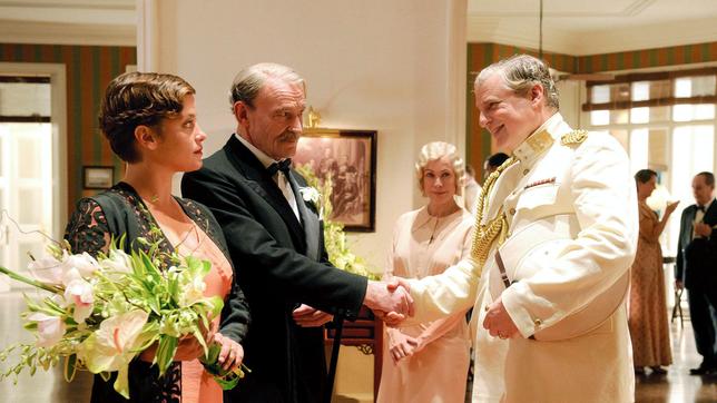 Hellen (Muriel Baumeister, links) und ihr Vater Arthur (Michael Mendl, 2.v. links) empfangen unter den argwöhnischen Blicken der Haushälterin Emmy Hartwig (Sonja Kirchberger) den Kolonialverwalter Joop van Boven (Filip Peeters).