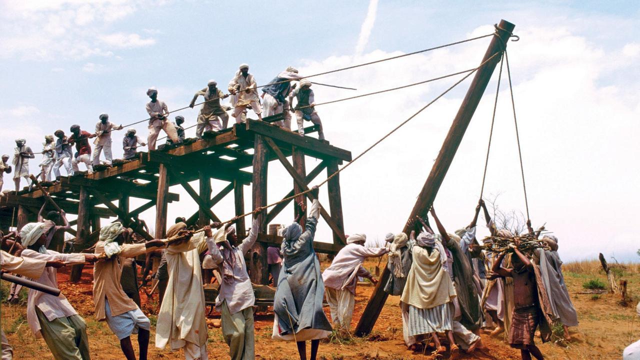 Indische und afrikanische Arbeiter bauen eine Eisenbahnbrücke über den Fluss Tsavo im heutigen Uganda.