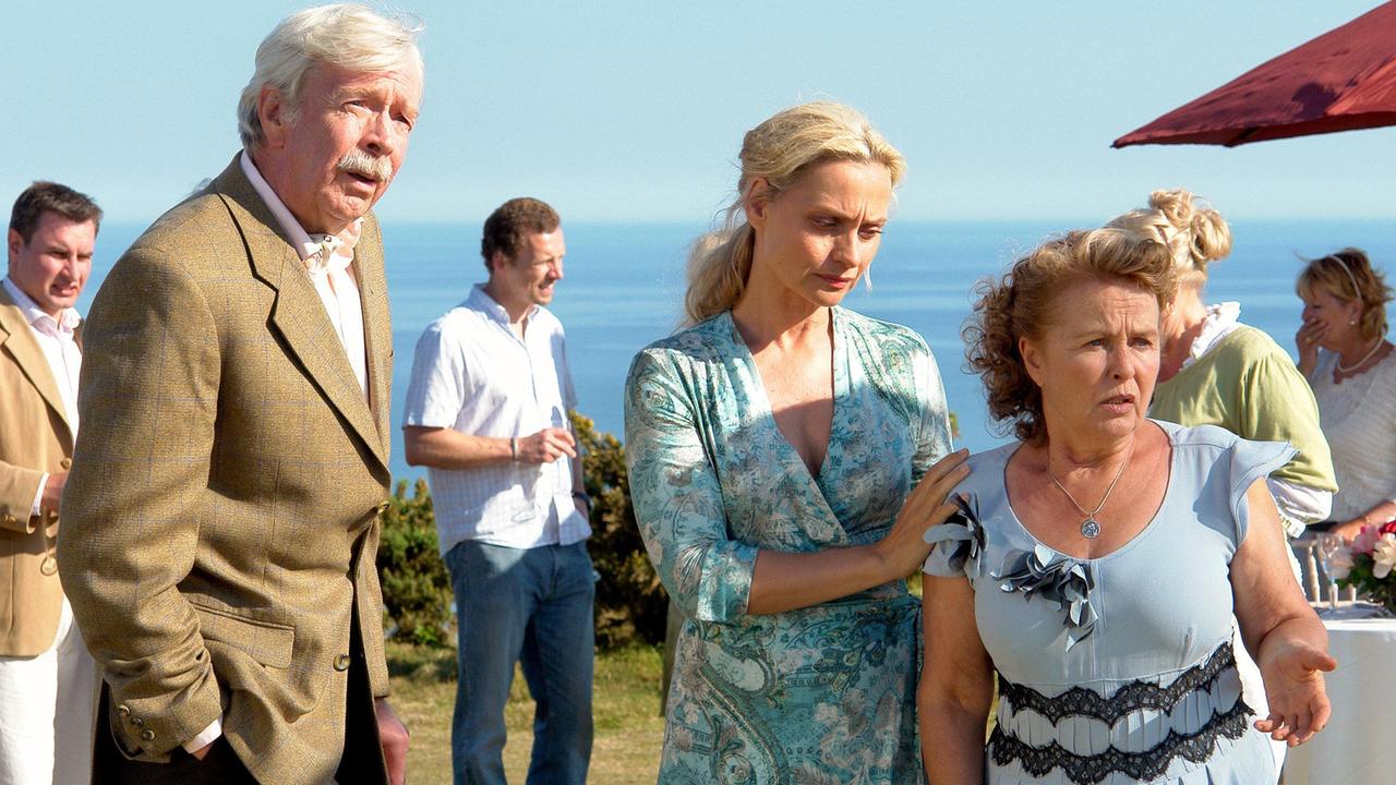 John Hamilton (Volkert Kraeft), seine Schwiegertochter Jane (Catherine Flemming, Mitte) und Claire Hickman (Petra Kelling) sind entsetzt über die aggressive Störung ihres Festes.