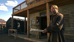 Jon (Mads Mikkelsen) startet einen Rachefeldzug für das Auslöschen seiner Familie. Nur die Banditen-Witwe Madelaine (Eva Green, hinten) hält zu ihm.