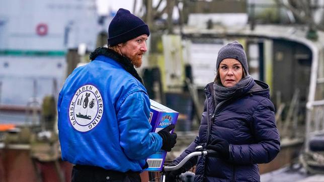 Karin Lossow (Katrin Sass) will Morten (Joen Højerslev) mit einer Kiste Schnaps milde stimmen.