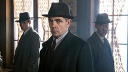 Kommissar Maigret (Rowan Atkinson) und seine Inspektoren Lapointe (Leo Staar, li.) und Janvier (Shain Dingwall, re.) nehmen das verlassene Bistro des Ermordeten unter die Lupe.