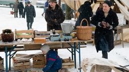 Marie (Christine Neubauer, re.) verkauft auf dem Markt Gemüse an die Kundin Schenkhofer (Johanna Bittenbinder, 2.v.re.), derweil ihr Sohn Felix (Eric und Marc Hermann, im Bild Eric) sich ganz alleine beschäftigt.
