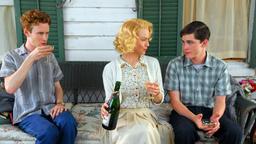Ann sitzt mit ihren zwei Söhnen auf der Terrasse.