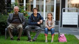 Opa (Vedat Erincin) sitzt mit Can (Jascha Baum) und Sevgi (Marlene Metternich) auf einer Bank.