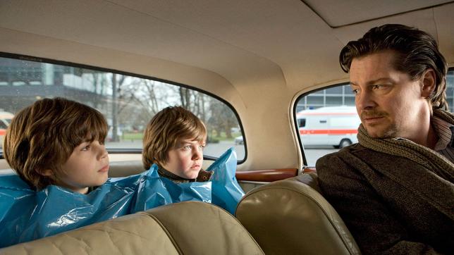 Hannes Herbst (Fritz Karl) zieht seinen Neffen Bruno und Jonathan Müllsäcke an, damit sie die Ledersitze seines Autos nicht schmutzig machen.