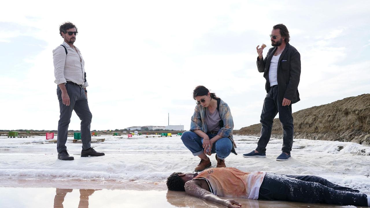 Raul Da Silva (Adriano Carvalho, li.), Carlos Esteves (Daniel Christensen) und Graciana Rosado (Eva Meckbach) untersuchen Jobes Leiche (Igor Regalla).