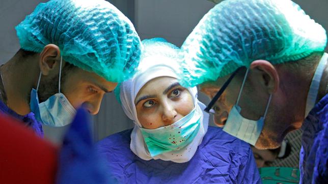 Bild: SWR/Danish Documentary Samaher, OP-Krankenschwester (Mitte) mit Dr. Salim (rechts) und einem weiteren Kollegen.