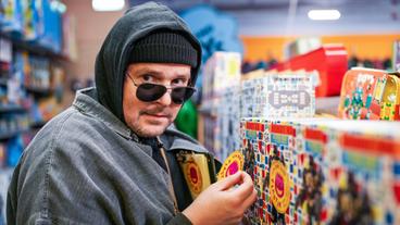 Stefan Steindl (Thomas Mraz) klebt Plastik-Warnkleber auf Spielzeugverpackungen in einem Spielzeuggeschäft im Einkaufszentrum. Weiteres Bildmaterial finden Sie unter www.br-foto.de.