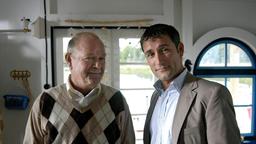 Unternehmer Kolditz (Dieter Mann) stattet Hans-Werner (Heikko Deutschmann) einen Besuch auf seinem Hausboot ab.